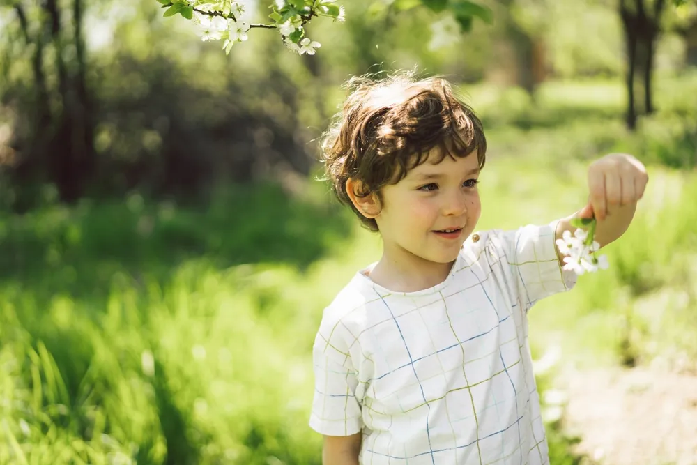 Un bambin heureux se promenant dans un jardin printanier