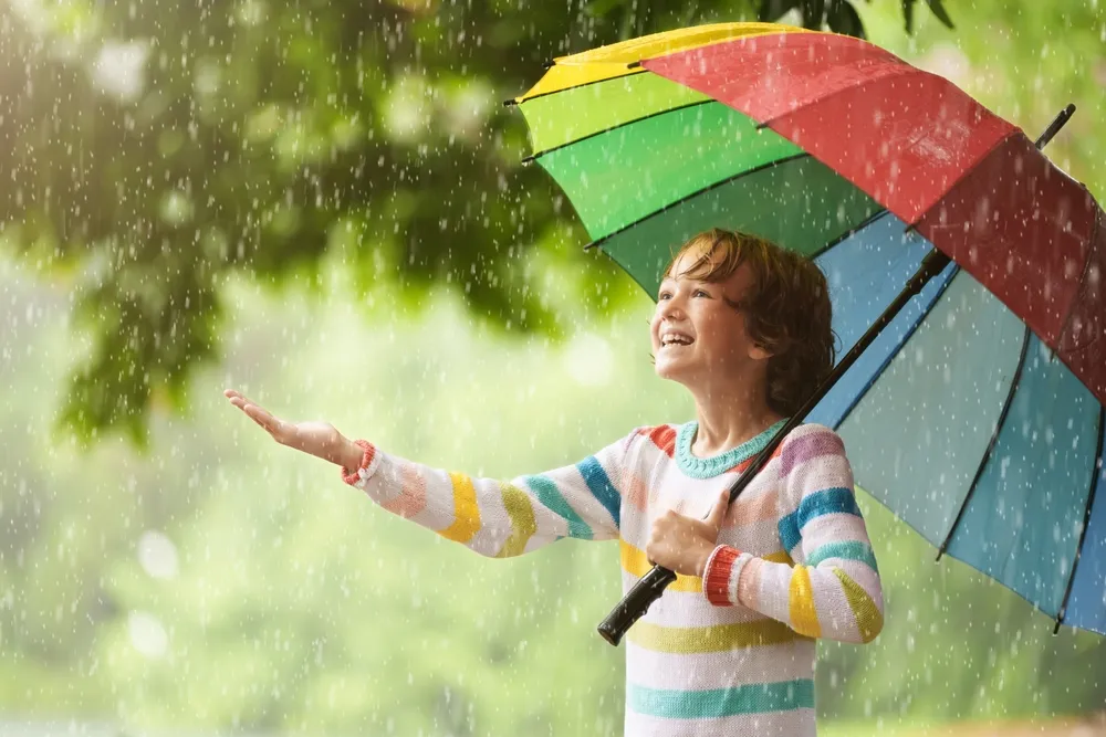 Enfant jouant sous la pluie