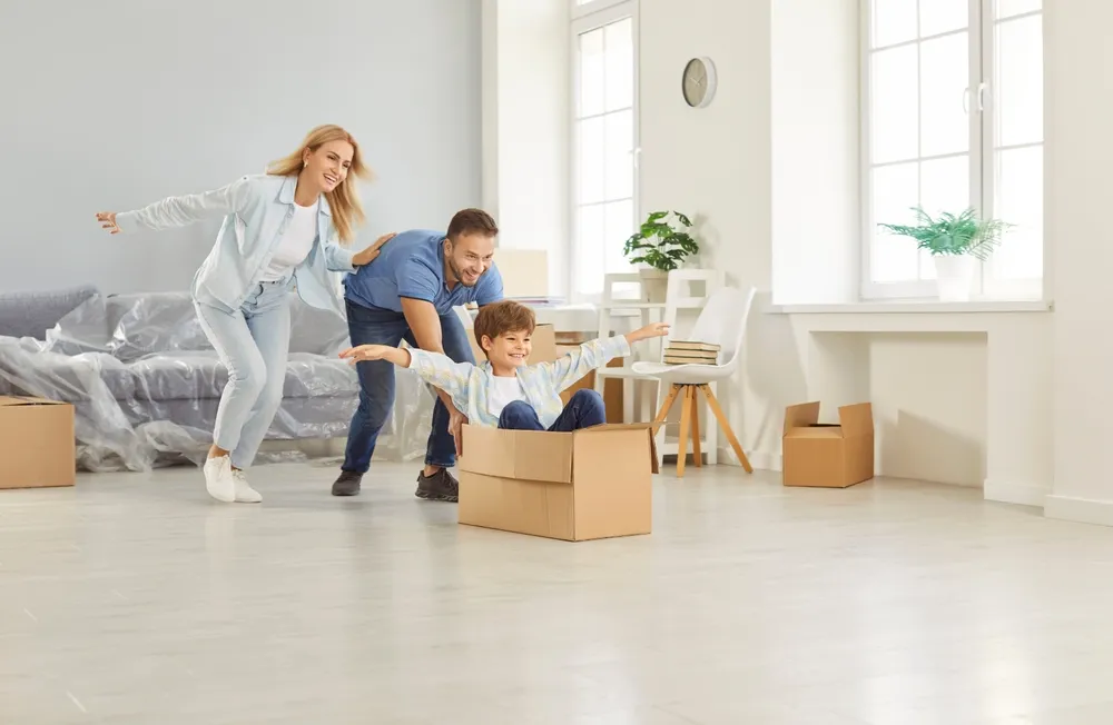 Parents et enfants jouant avec une boîte en carton