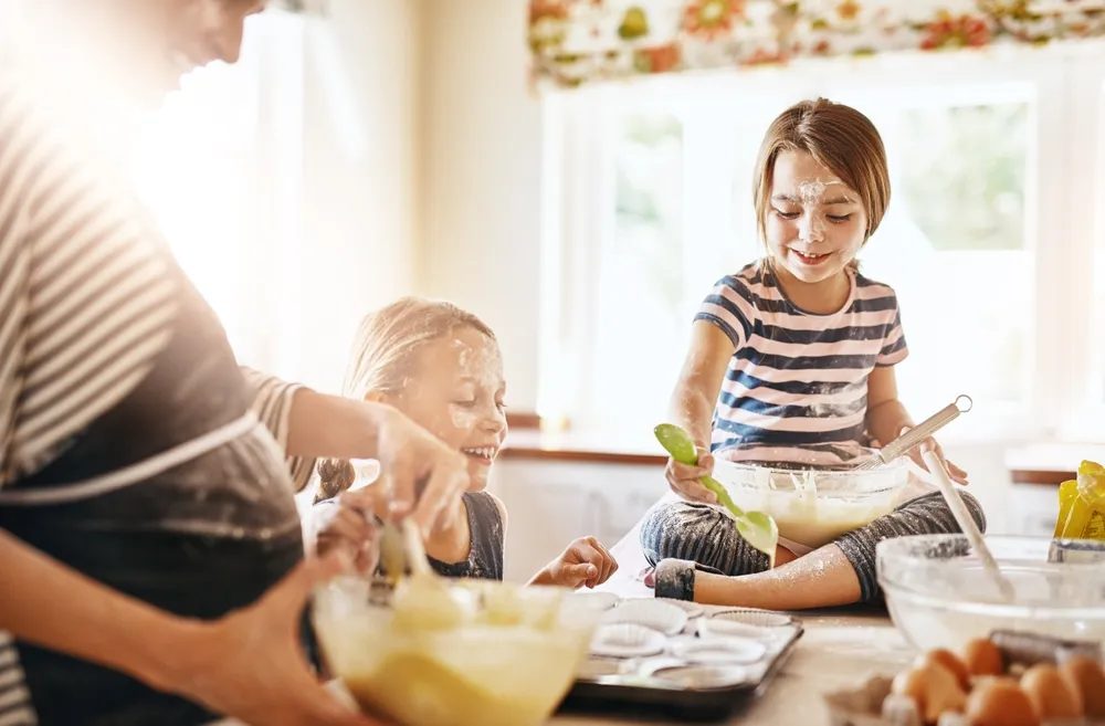 Mère et enfants jouant et cuisinant joyeusement dans la cuisine