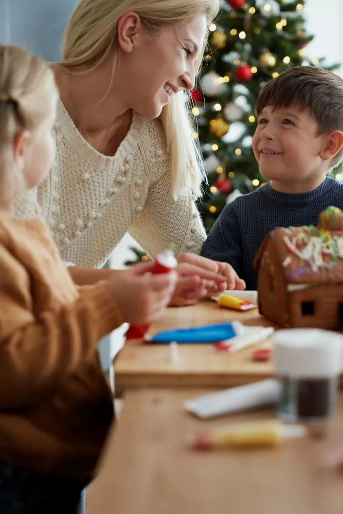 Une mère avec ses deux enfants faisant du bricolage à Noël